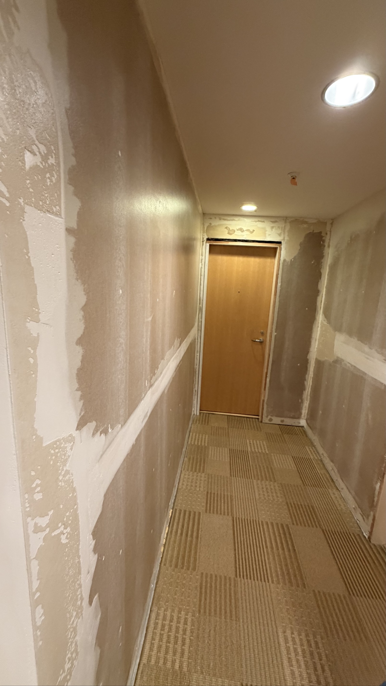 Hallway walls stripped and prepped for new wallpaper — high-rise repaint