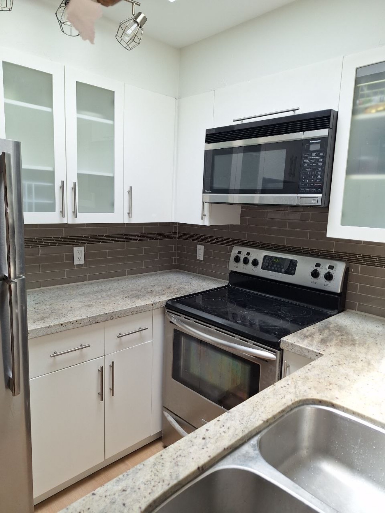 White kitchen cabinets fully refinished by Exceptional Painting Inc — project cost about $3,500