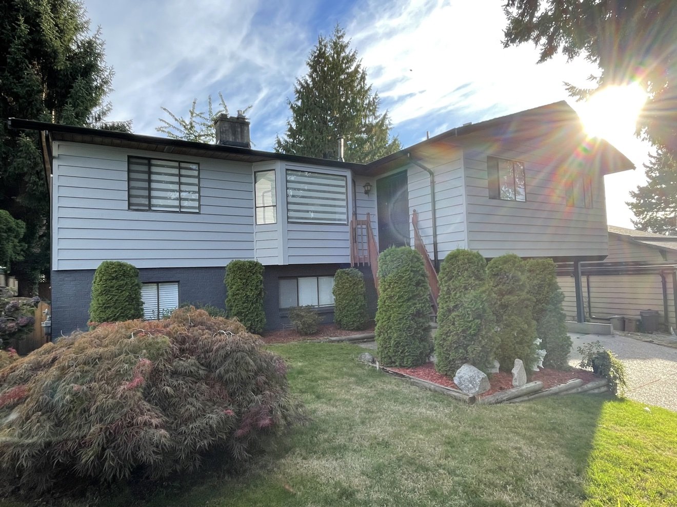 Grey house siding painted in bright sunlight by Exceptional Painting Vancouver